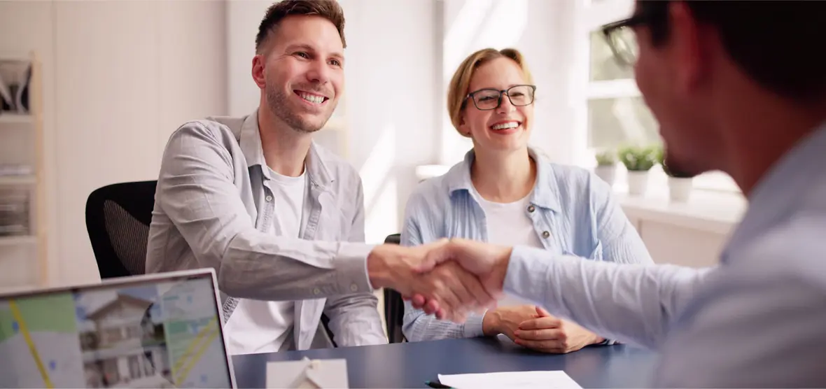 Handshake in a business meeting with couple.