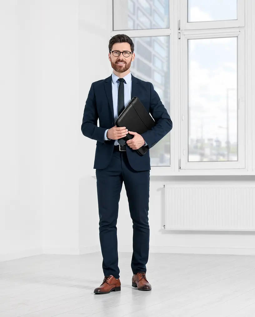 Man in suit holding a black folder.