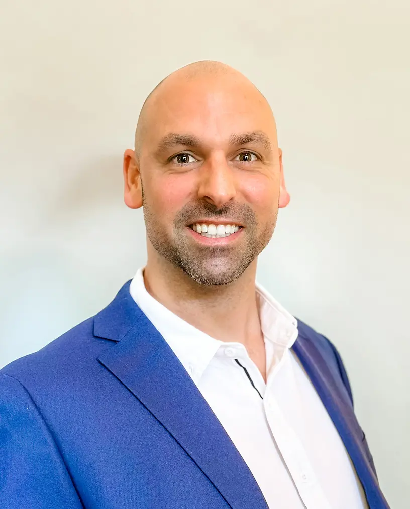 Smiling man in blue suit jacket.